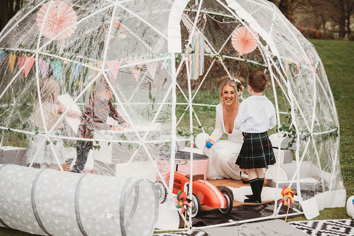 Bride and small child play inside igloo