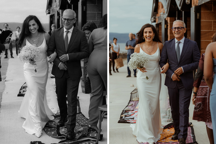 A Bride Walking Down Aisle On Arm Of Man Wearing Navy Suit