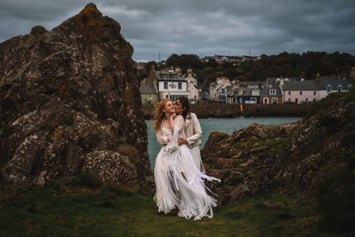 Two Brides Kissing By Rocks With Portpatrick In Background