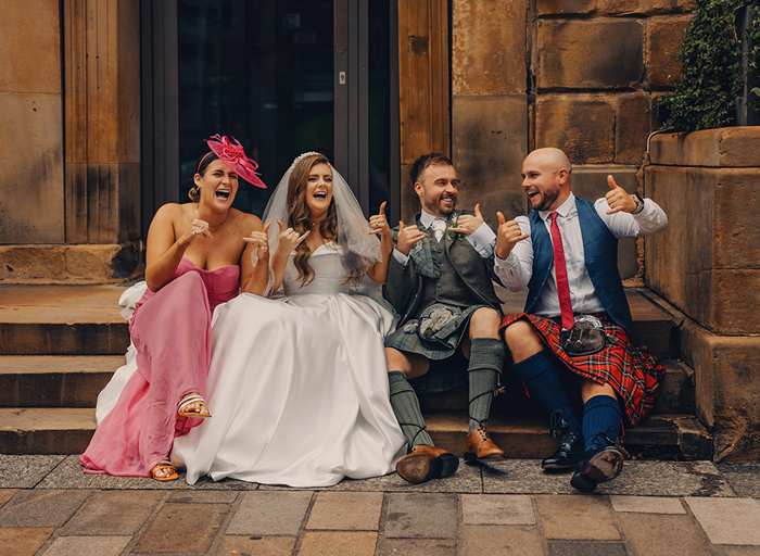 Four People Making Gesture Whilst Sitting On Stairs