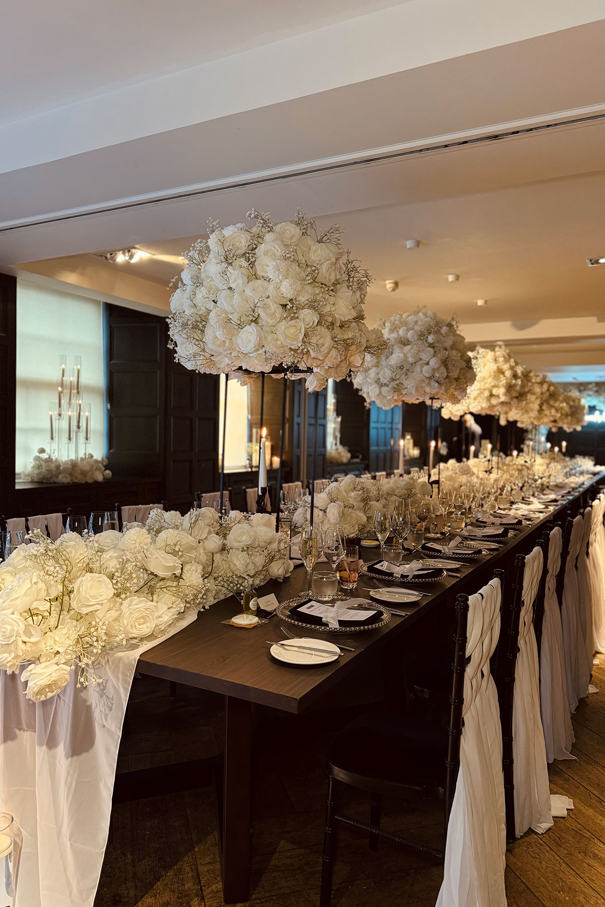 table set up with large floral centrepieces and white table runner for wedding dinner at kimpton blythswood square