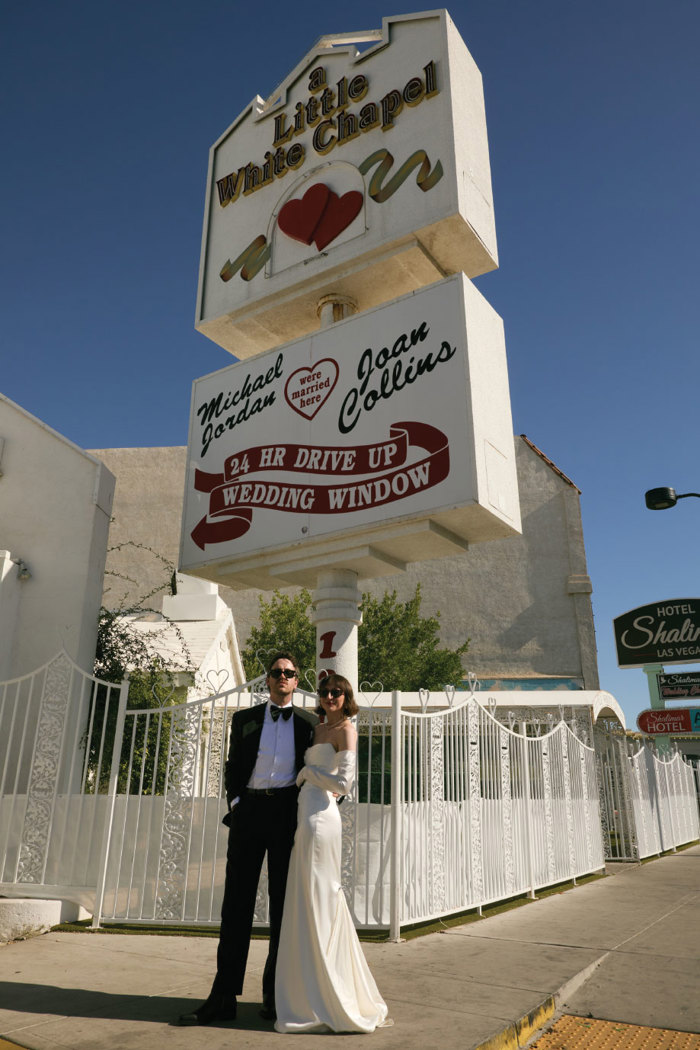 a bride and groom standing in front of a Little White Chapel in Las Vegas