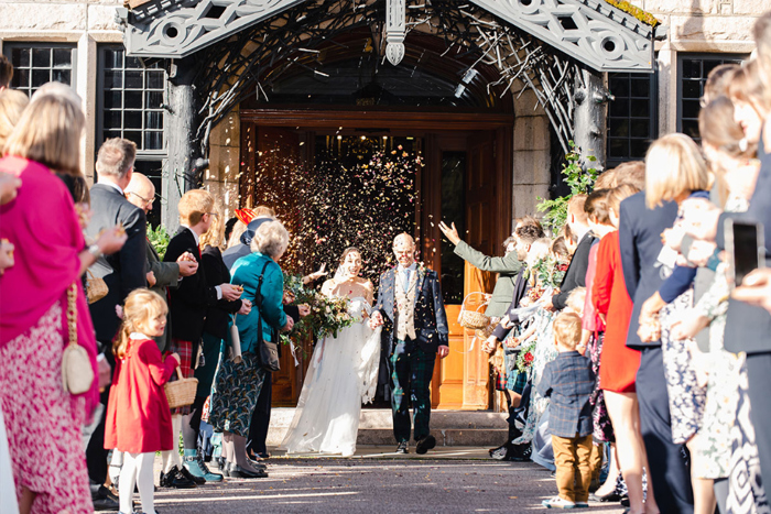 Bride and groom walk through confetti shower