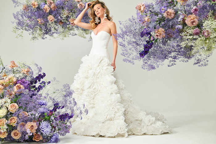 bridal model wears strapless white wedding dress with a full long skirt consisting of large textured flowers