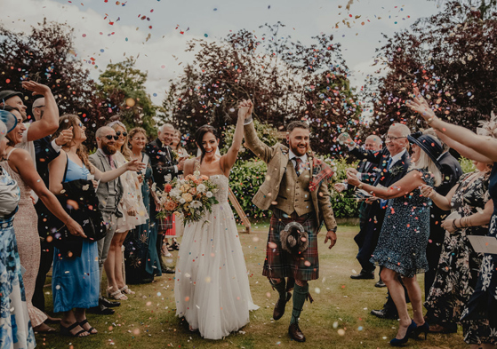 Couple walk through confetti shower