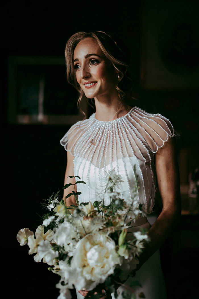 bride holds bouquet with white flowers and foliage