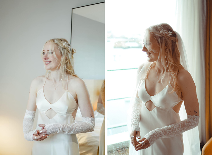 a bride wearing a satin slip-style wedding dress with diamond cutout detail below bust, removable long lace sleeves and long pearl drop earrings