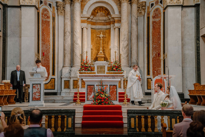 Bride and groom listen to a reading during ceremony at St Aloysius Church