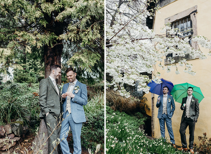 two grooms laughing while posing for photos under a tree at Royal Botanic Garden Edinburgh on right. Two grooms holding blue and green umbrellas while standing against a yellow wall on right. There are snowdrops at their feet and a cherry blossom tree hangs overhead