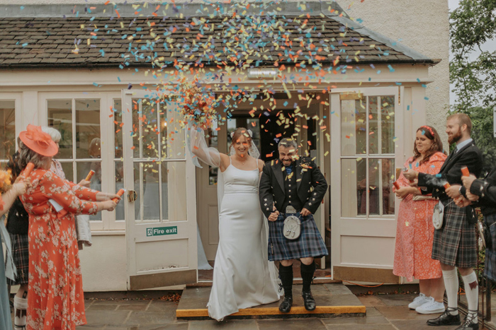 Couple walk through confetti shower