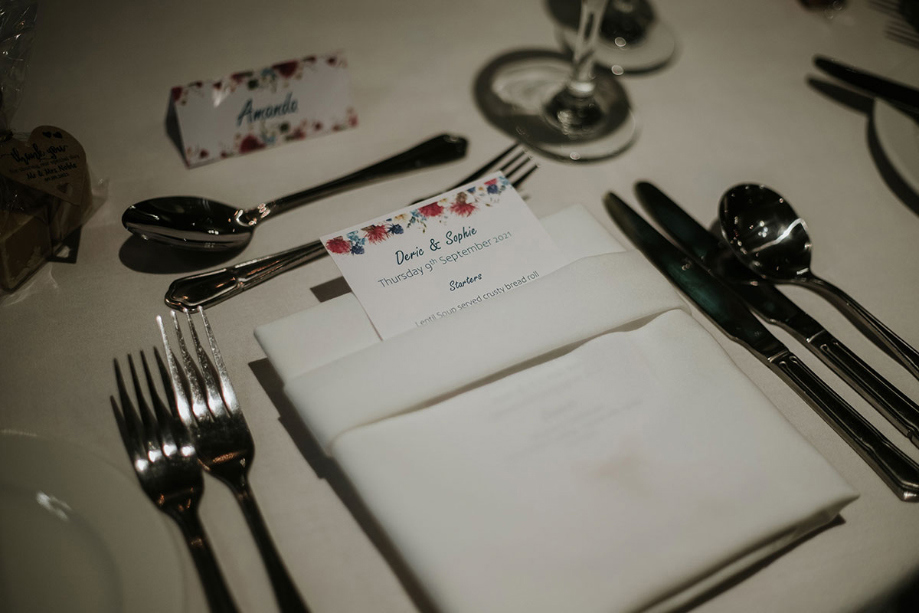 Floral Wedding Place Cards On A Table Set For Dinner