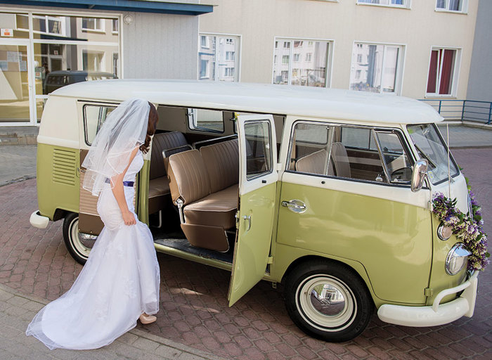 A bride getting into a green VW campervan