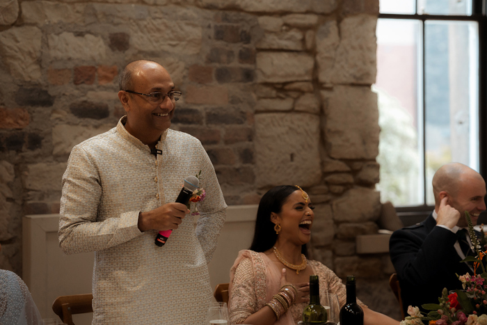 A Man Wearing An Ivory Salwar Kameez Standing Holding A Microphone At The Haberdashery In Glasgow