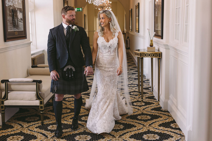 Bride and groom walk down corridor in Trump Turnberry