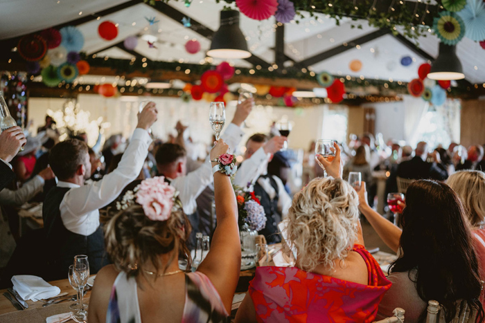 Guests raise their glasses to toast happy couple