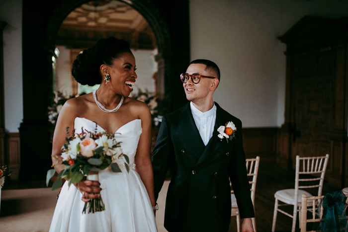 Couple portrait of bride and groom walking down aisle 