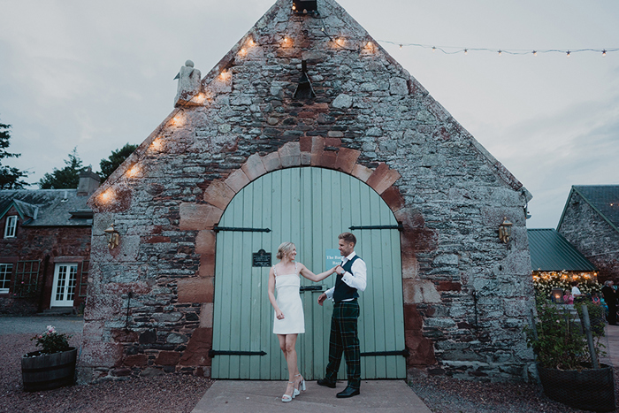 A Bride And Groom Pose By A Green Barn Door At Wedderlie House