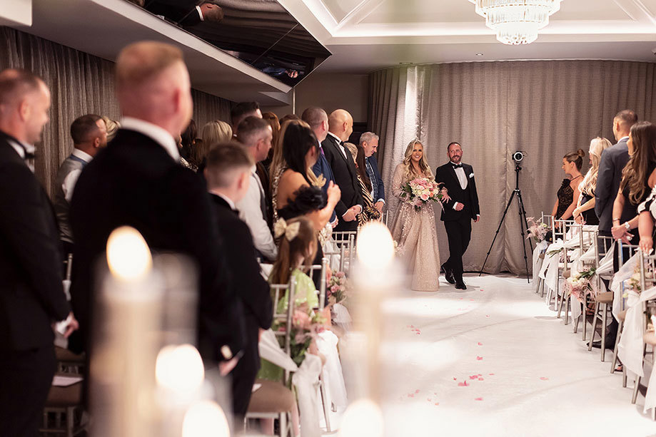 a bride walking down aisle on arm of a person at the Torrance Hotel