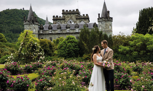 couple looking at one another on wedding day in front of castle venue