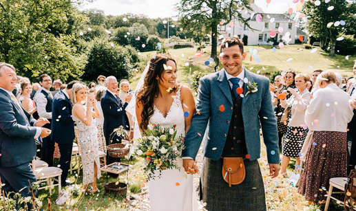 couple smiling as they walk back up the aisle after getting married