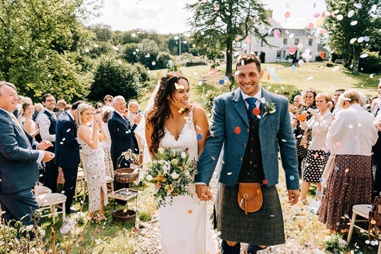 couple smiling as they walk back up the aisle after getting married