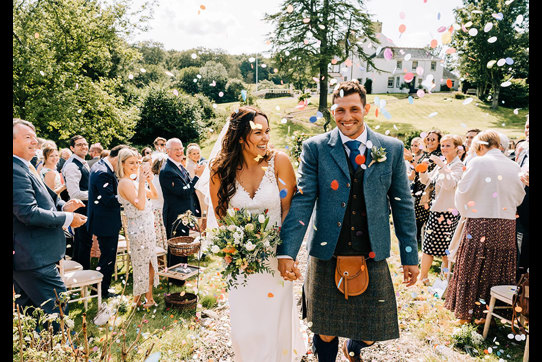 couple smiling as they walk back up the aisle after getting married