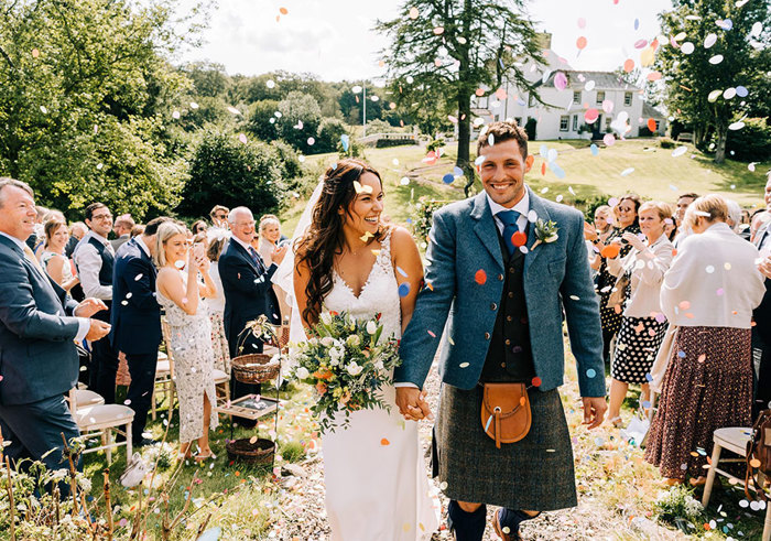 couple smiling as they walk back up the aisle after getting married