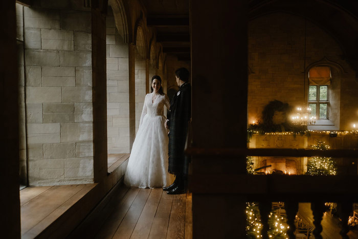 a bride and groom standing in the Minstrel's Gallery at Achnagairn Castle.