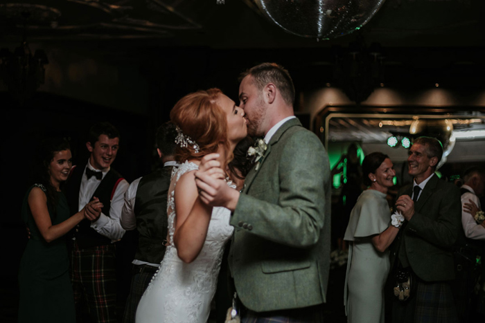 A Bride And Groom Kissing During First Dance