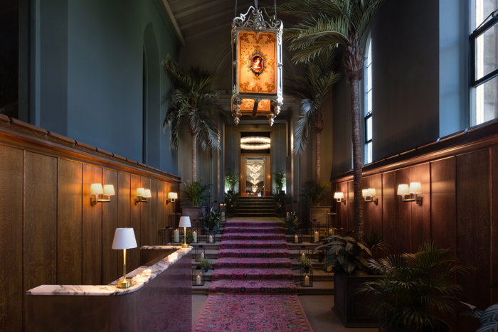 mar hall's new concierge desk with wood panelling and green plants on display
