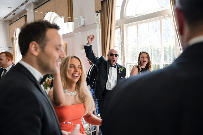 Groomsman cheers during dancing