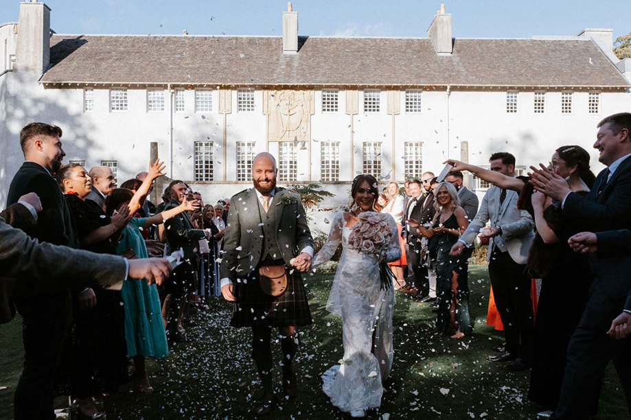 Guests throw confetti on newlywed couple