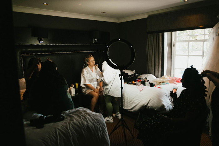 A Bride In A Bedroom Getting Her Makeup Done