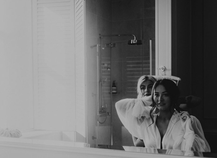 Bride looking into mirror as she gets ready