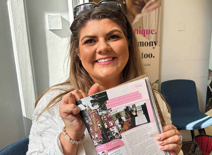 woman smiling holding up magazine