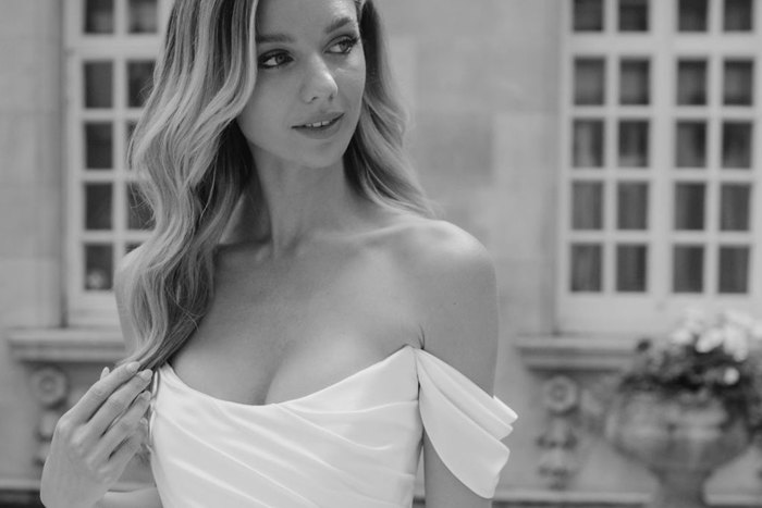 close up black and white image of a woman in a structured off the shoulder gown