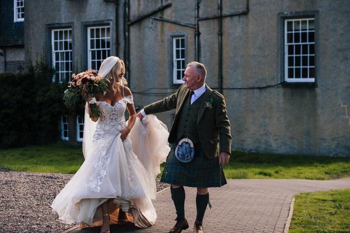 Bride and father walk outside