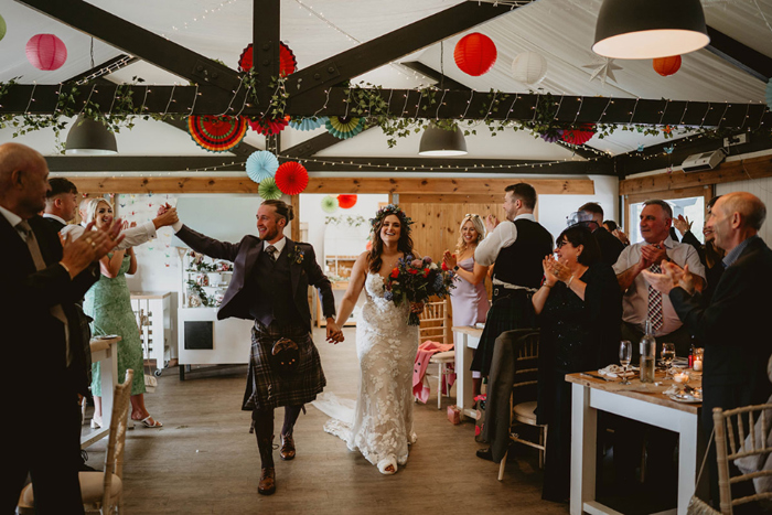 Bride and groom enter wedding venue hand in hand