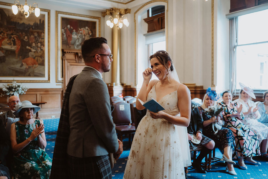 Bride wipes a tear away during her vows 