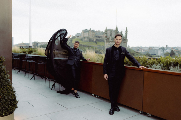 People On A Rooftop With Views Of Edinburgh Castle