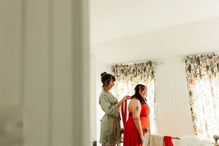 Bridesmaid being helped into her dress