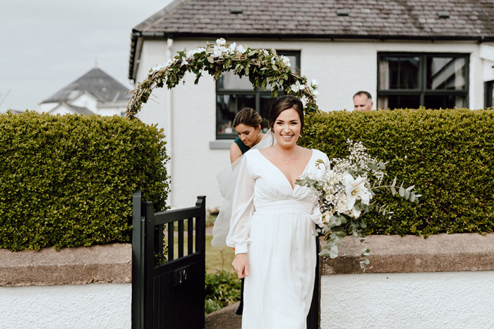 Bride leaving house holding her bouquet 