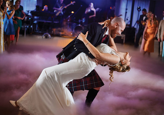 Bride and groom dancing surrounded by smoke