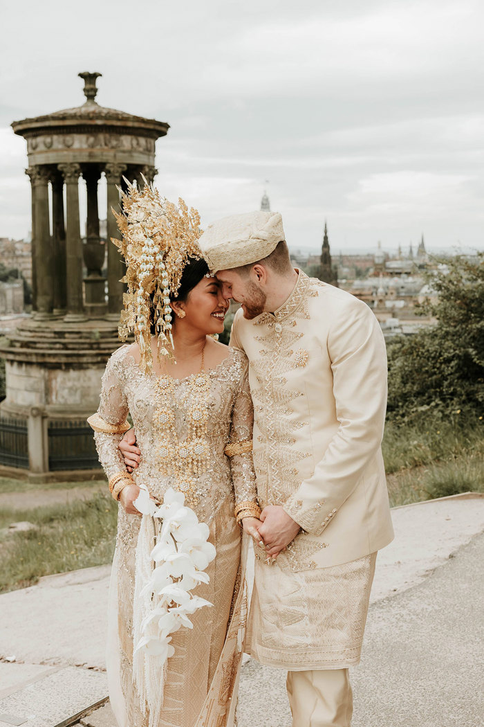 bride and groom smiling in edinburgh with indonesian wedding outfits