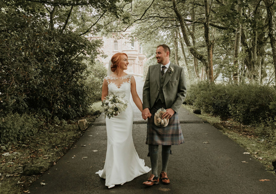 A Bride And Groom Walking Down Drive At Cornhill Castle