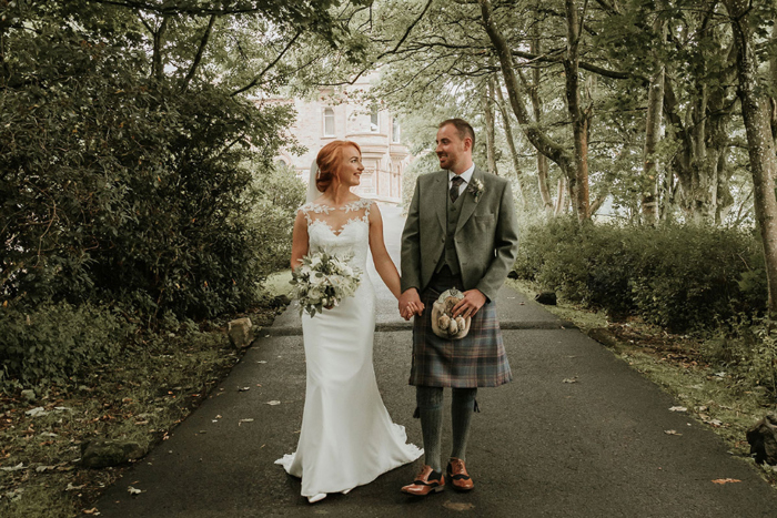 A Bride And Groom Walking Down Drive At Cornhill Castle