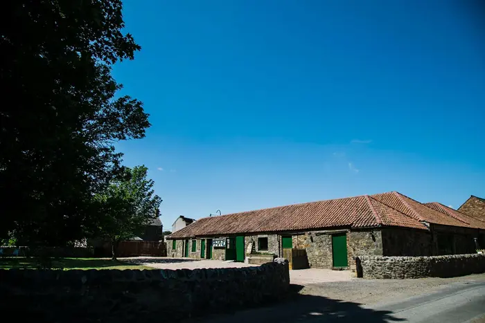 a small stone building with a red roof