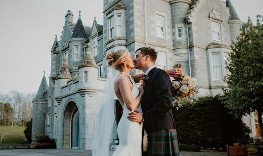 bride and groom kiss in front of ardoe house