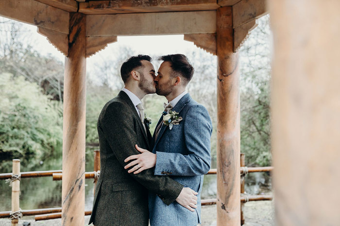 Two men kissing under a gazebo at Royal Botanic Garden Edinburgh.