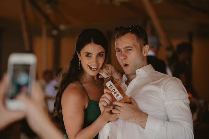 A Lady And A Man Posing For A Photo With A Bottle Of Brose